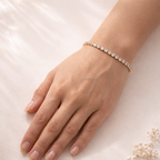 A classic gold-plated tennis bracelet for women featuring a continuous row of brilliant round-cut stones, shown on a model hand