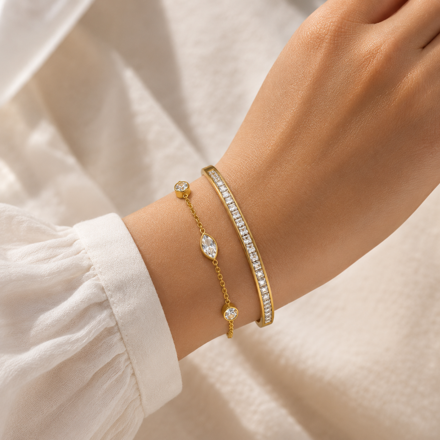 A close-view of a two-piece gold-plated bracelet stack for women featuring a bangle and a delicate bezel-set crystal chain bracelet.