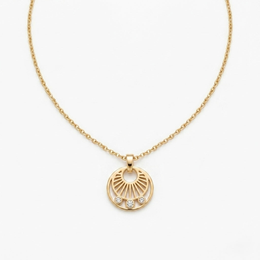 A gold-plated stainless steel necklace for women featuring a circular sunburst pendant with three small crystals at the bottom, shown against a white background
