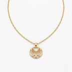 A gold-plated stainless steel necklace for women featuring a circular sunburst pendant with three small crystals at the bottom, shown against a white background