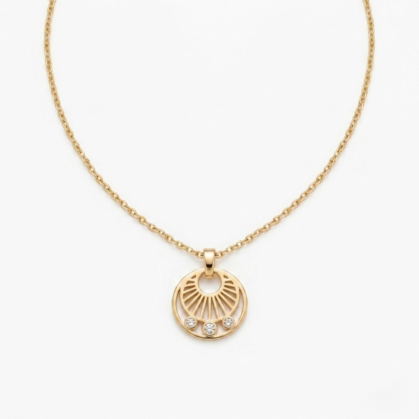 A gold-plated stainless steel necklace for women featuring a circular sunburst pendant with three small crystals at the bottom, shown against a white background