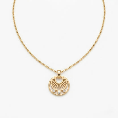 A gold-plated stainless steel necklace for women featuring a circular sunburst pendant with three small crystals at the bottom, shown against a white background