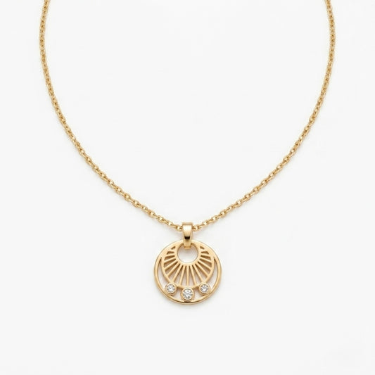 A gold-plated stainless steel necklace for women featuring a circular sunburst pendant with three small crystals at the bottom, shown against a white background