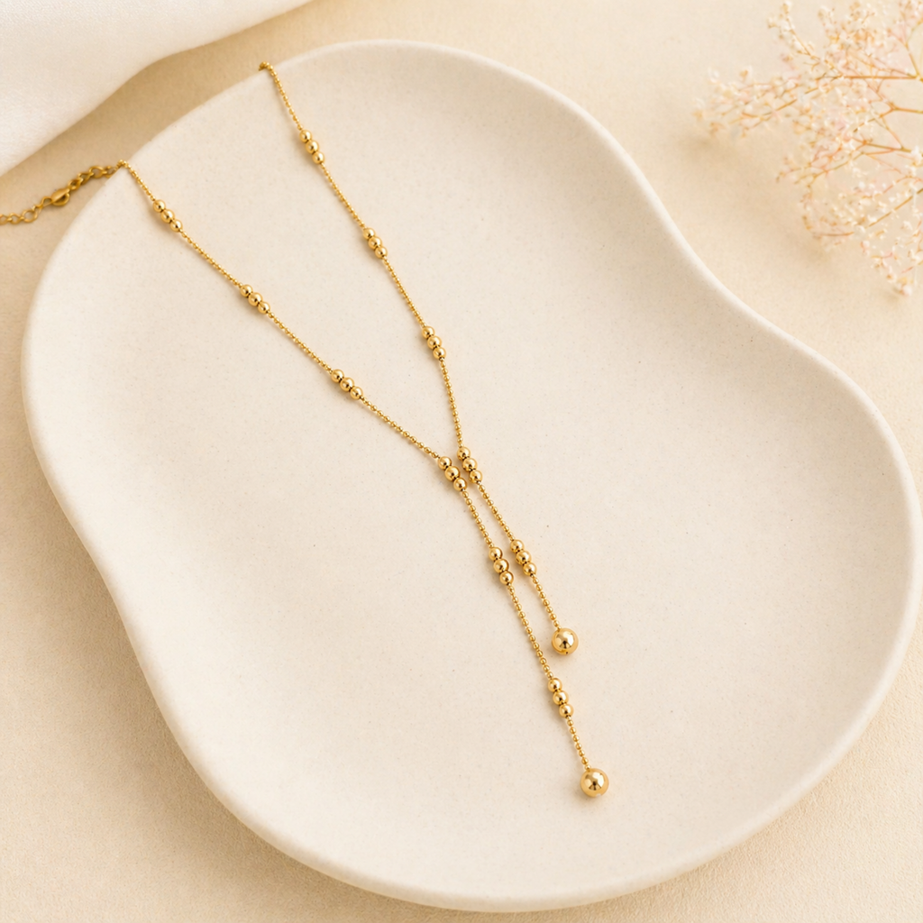 A gold-plated stainless steel chain for women featuring a double-strand Y-drop lariat design with gold beads