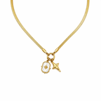 A close-view of a gold-plated stainless steel chain for women featuring a flat snake chain and two celestial star charms, one with a pearl inlay