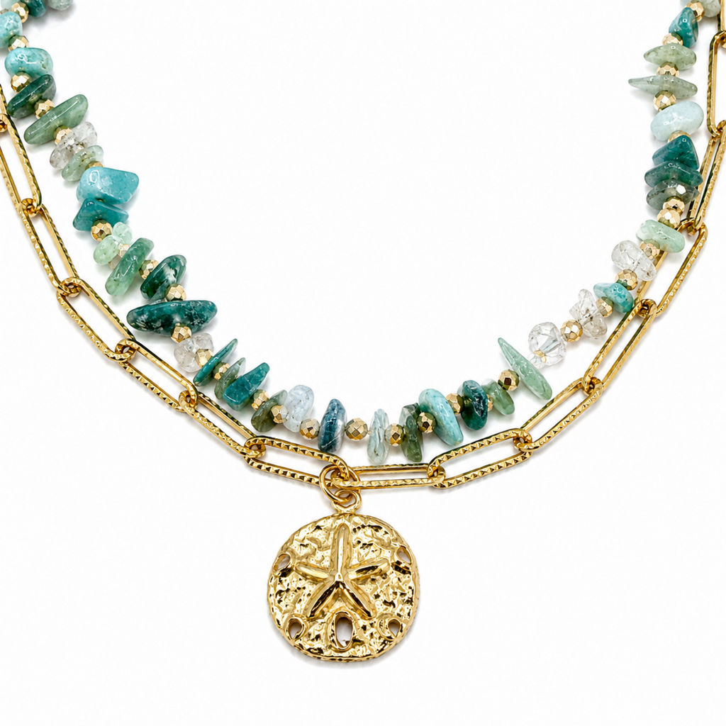 A close-view of a gold-plated dual-layer ladies bracelet featuring a paperclip chain, green stones, and a textured starfish charm.