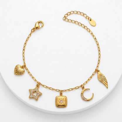 A gold-plated charm bracelet for women featuring five dangling celestial charms including a sun, star, moon, heart, and wing.