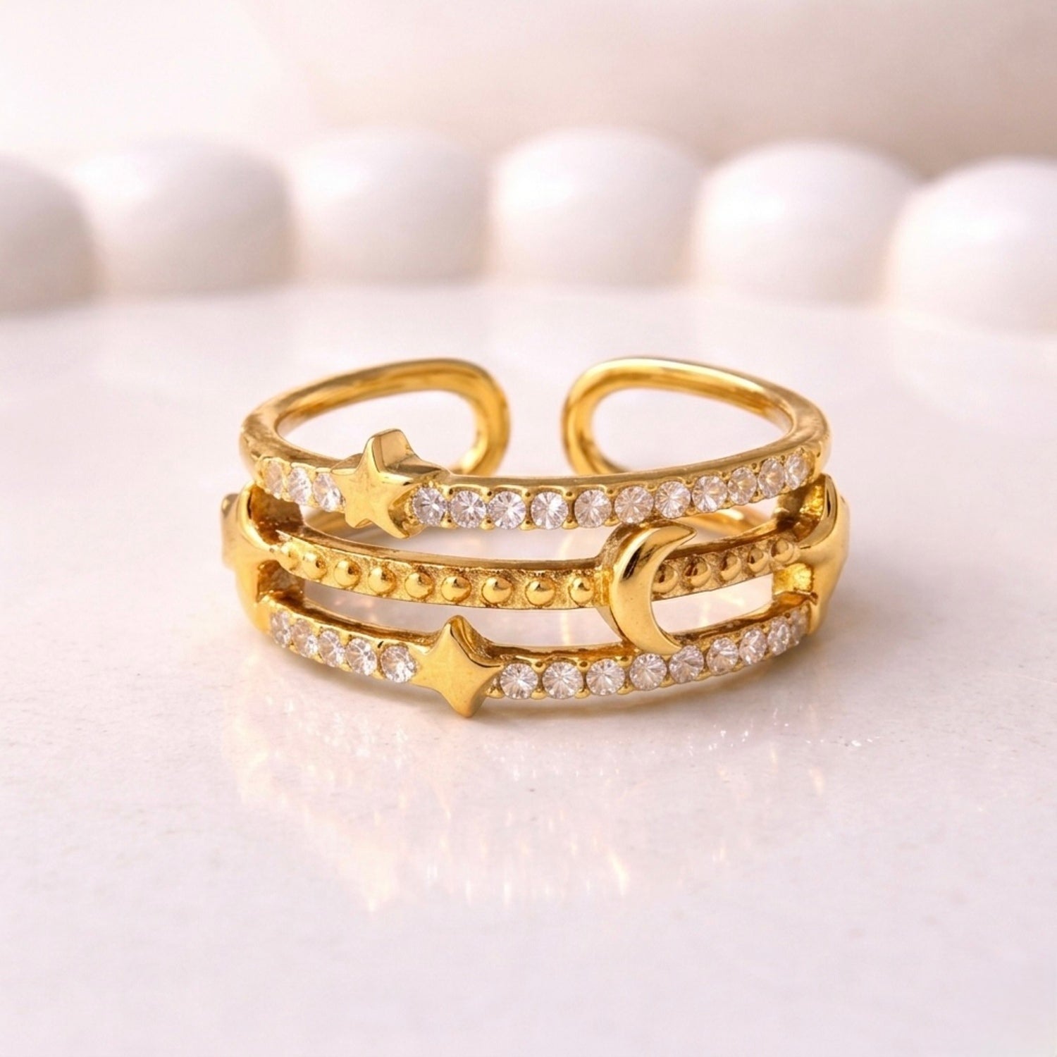 gold plated adjustable ring for women with a triple-band design featuring a crescent moon, stars, and rows of sparkling stones on a white surface