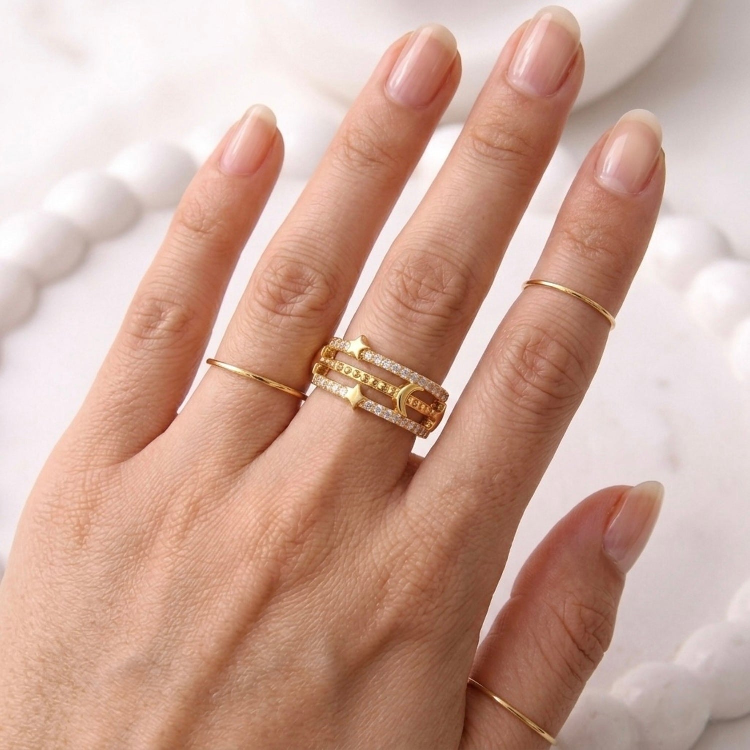 gold plated adjustable ring for women with a triple-band design featuring a crescent moon, stars, and rows of sparkling stones on a model hand
