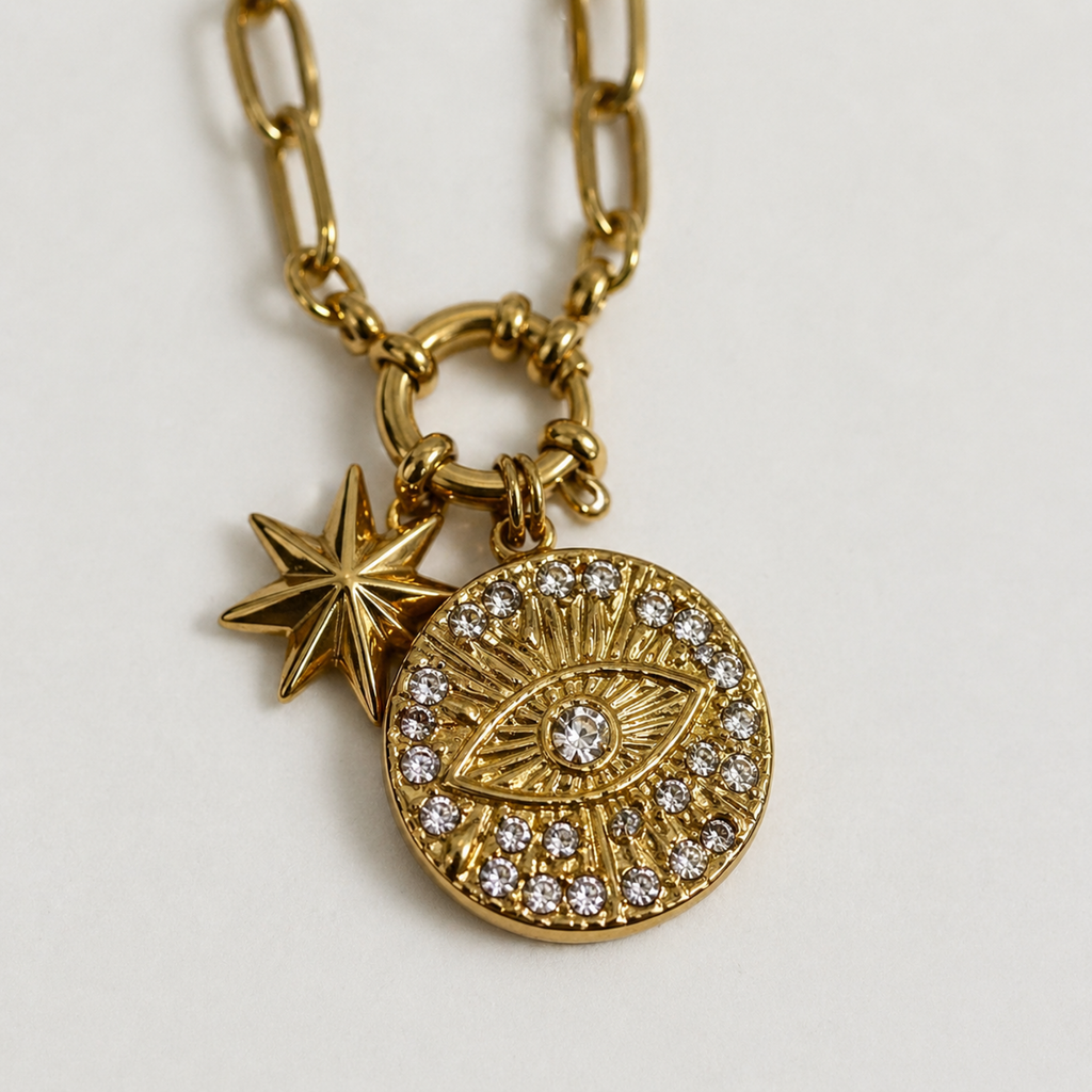 A close view of a gold-plated stainless steel chain for women featuring a paperclip link design with an evil eye medallion and star charm