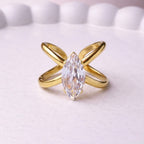 Gold plated adjustable statement ring for women featuring a large white-cut white stone crystal centered on a unique intersecting X-shaped band, displayed on a white background.