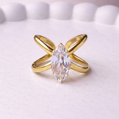 Gold plated adjustable statement ring for women featuring a large white-cut white stone crystal centered on a unique intersecting X-shaped band, displayed on a white background.