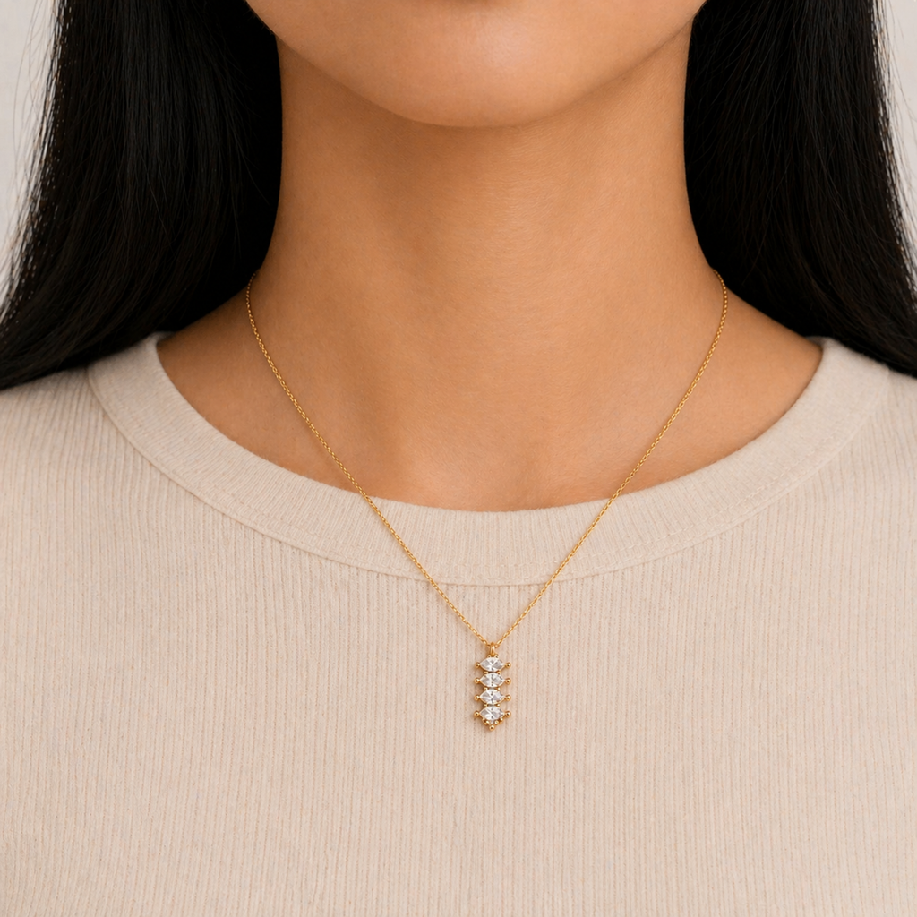 A gold-plated stainless steel chain for women featuring a vertical pendant with four stacked marquise-cut crystals, shown on a model
