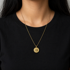 A gold-plated stainless steel chain for women featuring a circular medallion pendant with an embossed star pattern and seven sparkling crystals on a model