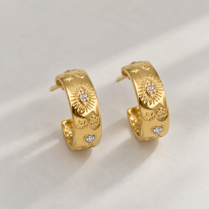 Gold sunburst hoop earrings for women with celestial star, heart and floral motifs and sparkling crystal accents