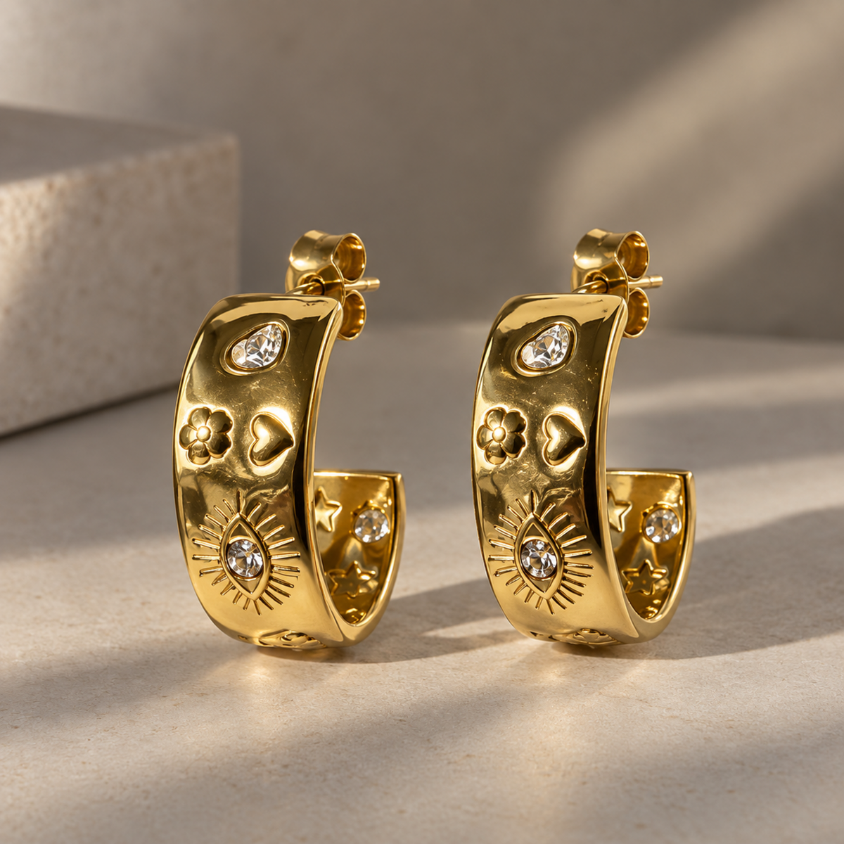 Gold sunburst hoop earrings for women with celestial star, heart and floral motifs and sparkling crystal accents