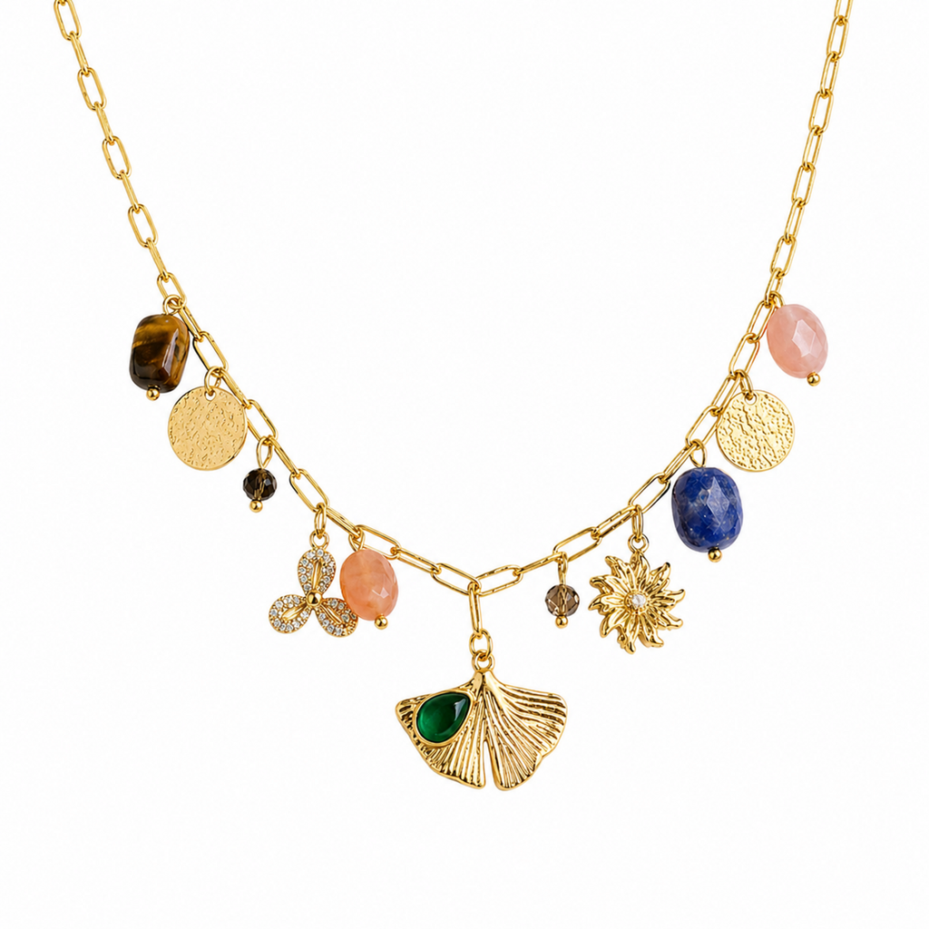 A close-view of a gold-plated stainless steel chain for women featuring paperclip links and a variety of charms including a ginkgo leaf, lapis lazuli, and rose quartz beads