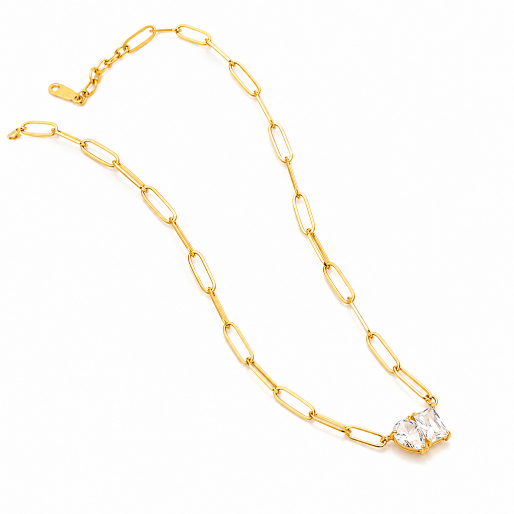 Gold chain necklace with a clear crystal pendant on a white background