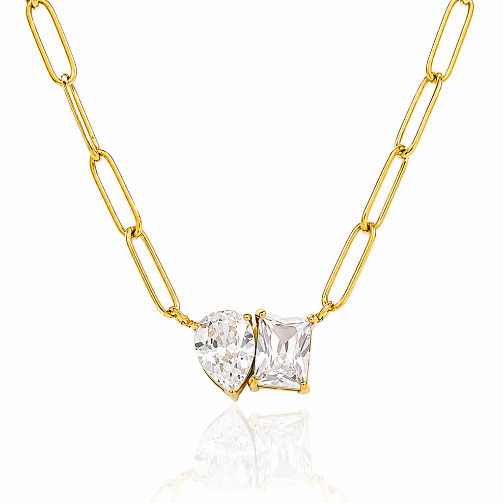 Gold chain necklace with two clear gemstones on a white background