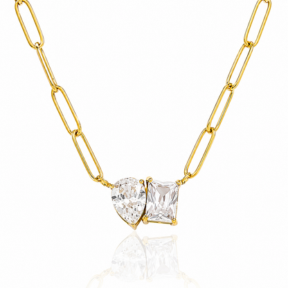 Gold chain necklace with two clear gemstones on a white background