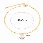 A gold-plated stainless steel chain for women featuring an elongated paperclip link design with a central pendant made of a pear-shape and emerald-shape stone joined together.