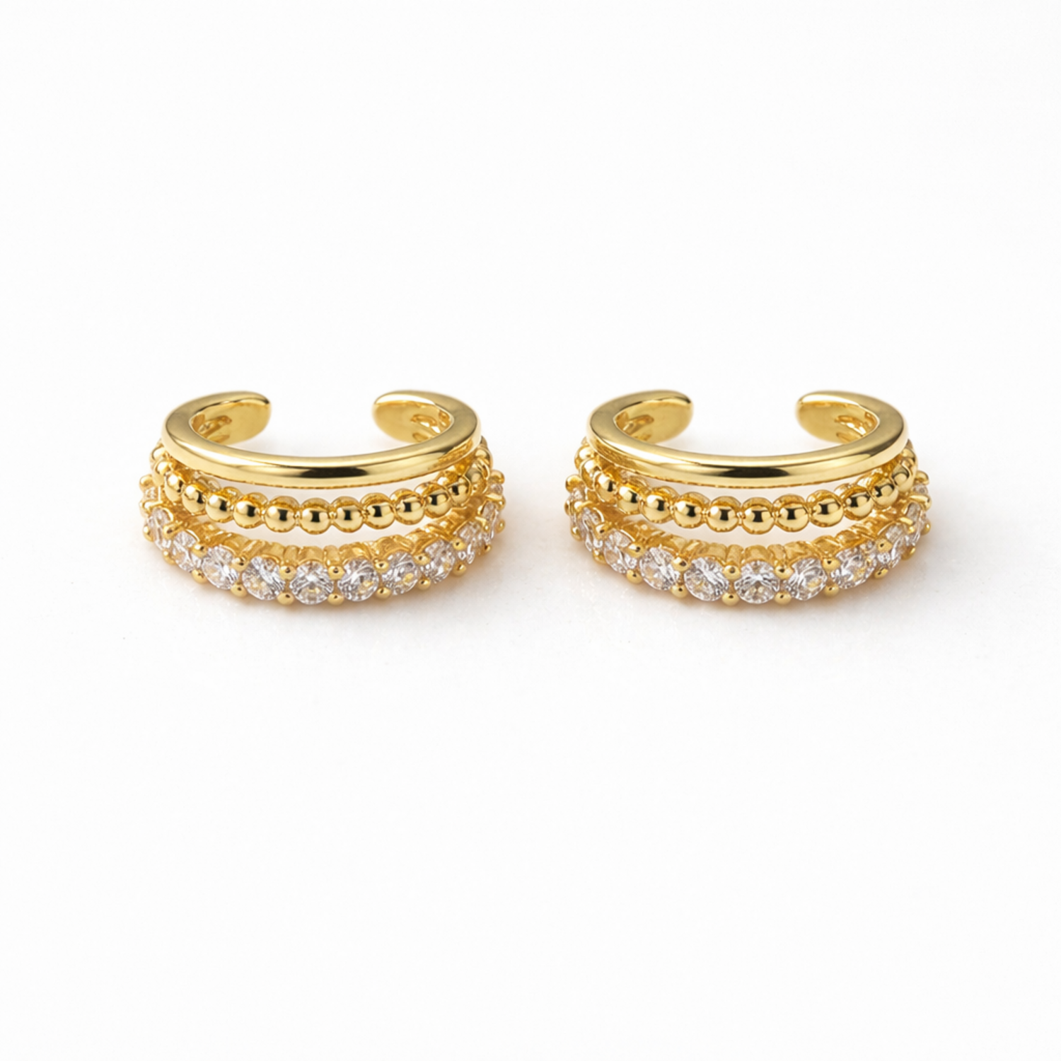 A pair of gold-plated triple-band ear cuff earrings for women on a white background