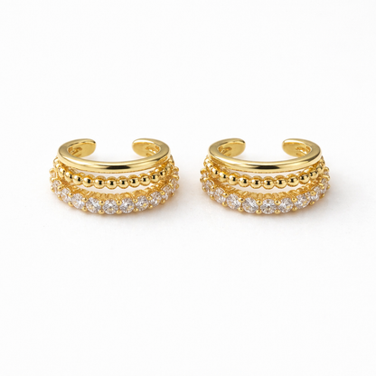 A pair of gold-plated triple-band ear cuff earrings for women on a white background