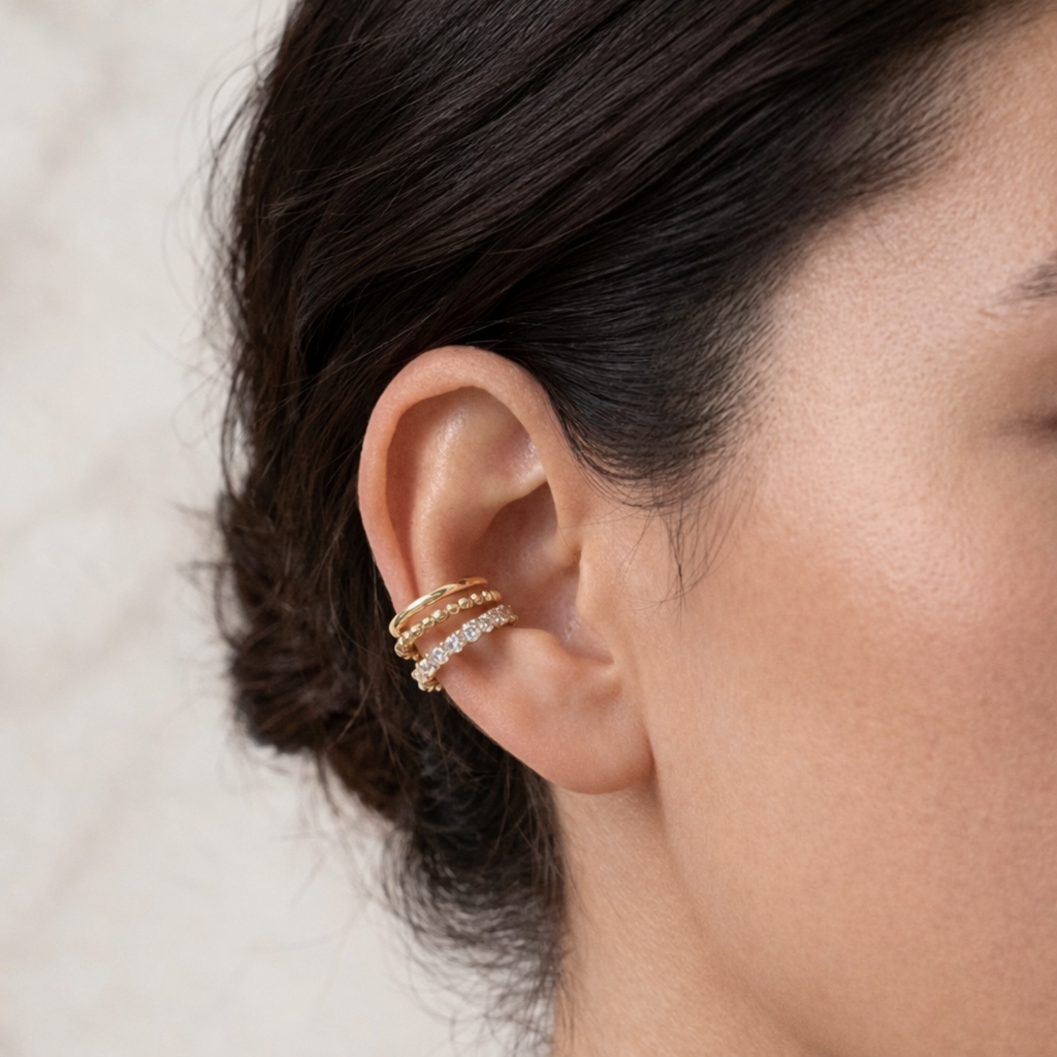A gold-plated triple-band ear cuff earrings for women on a model ear
