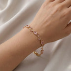 A close-view of a  gold-plated tulip vine chain bracelet for women featuring soft pink oval and marquise-cut stones, shown on a clean white background