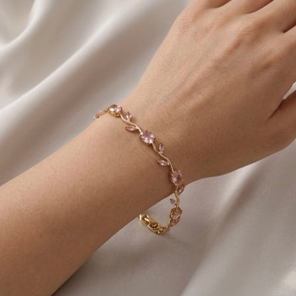 A close-view of a  gold-plated tulip vine chain bracelet for women featuring soft pink oval and marquise-cut stones, shown on a clean white background