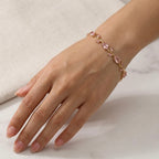 A close-view of a  gold-plated tulip vine chain bracelet for women featuring soft pink oval and marquise-cut stones, shown on a clean white background