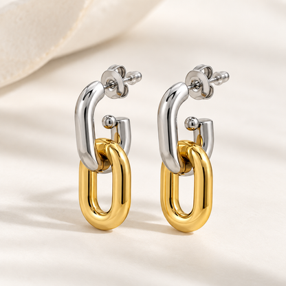 Two-tone gold and silver interlocking drop earrings for women with a sleek elongated loop design and polished finish on a neutral background