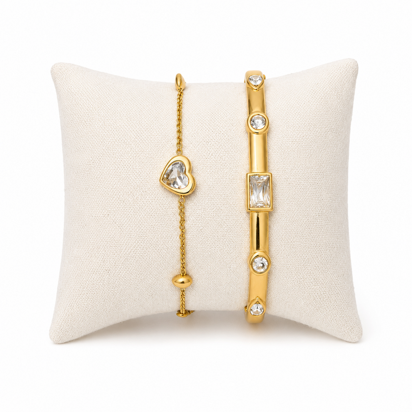 A premium two-piece gold-plated bracelet stack for women featuring a gold baguette station bangle and a fine link chain with a single heart crystal charm
