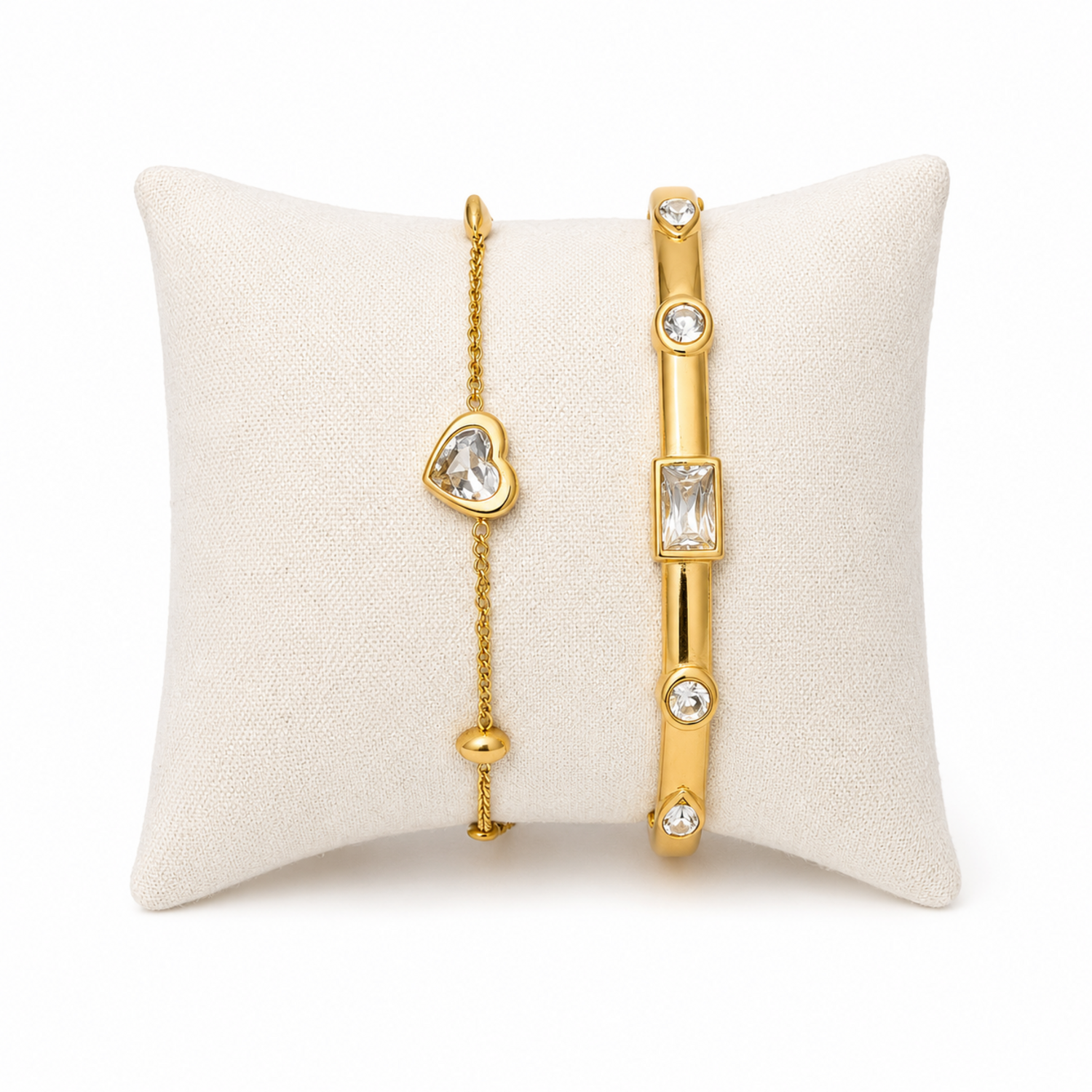 A premium two-piece gold-plated bracelet stack for women featuring a gold baguette station bangle and a fine link chain with a single heart crystal charm
