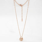 Rose gold necklace with a clover pendant on a white background