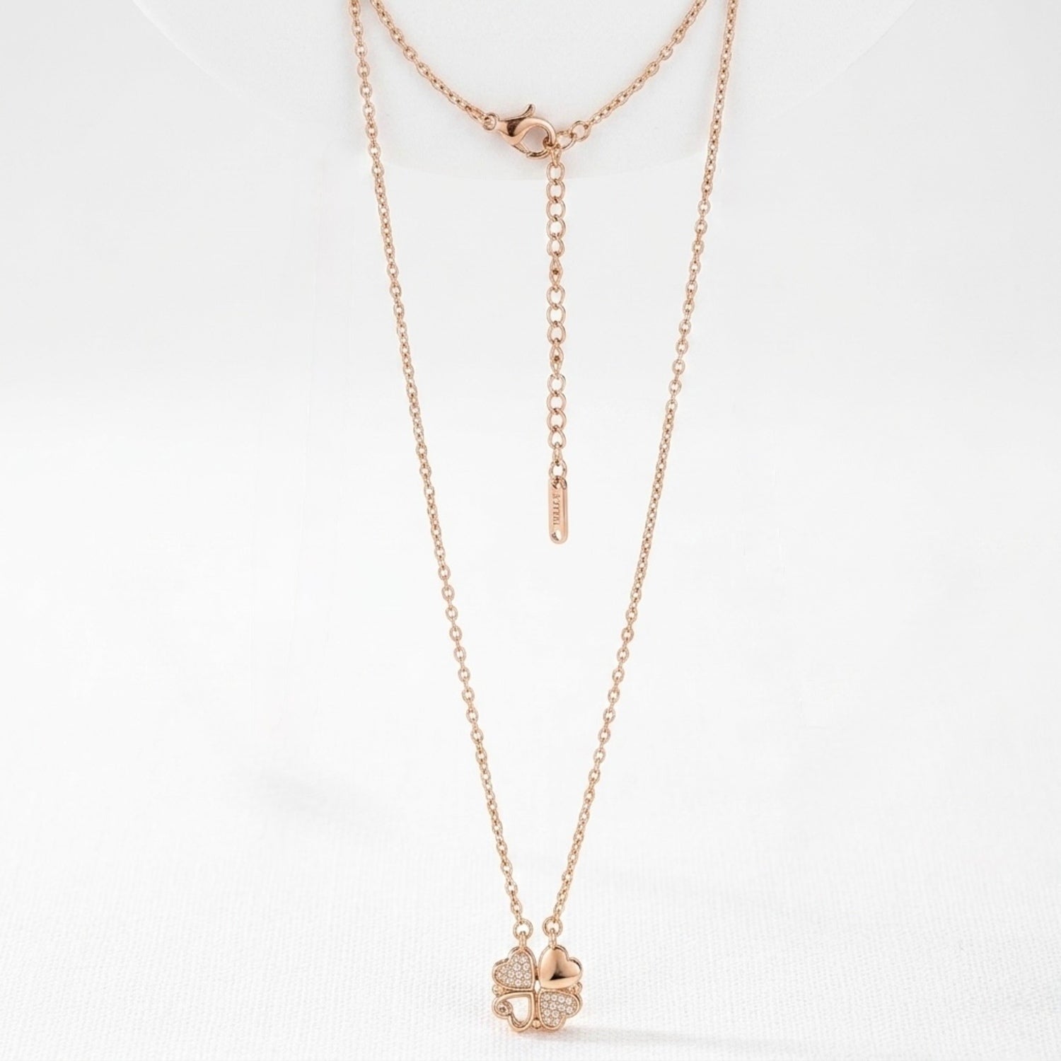 Rose gold necklace with a clover pendant on a white background