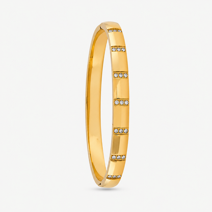 A close-view of a Crystal Bangle Bracelet with rectangular clear crystal accents on a gold-plated band.