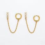 A pair of gold-plated ear chain earrings for women connecting a shimmering crystal bar stud to a small gold hoop with a fine chain