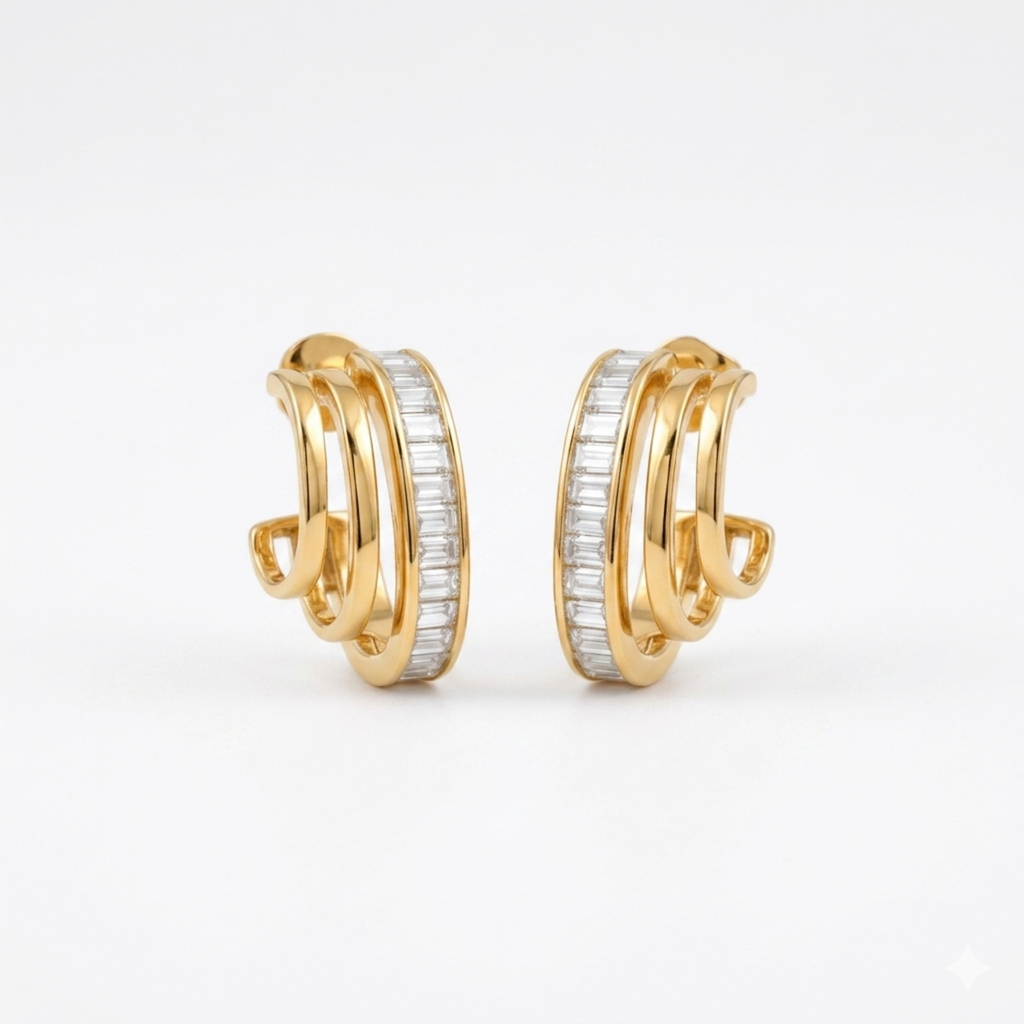 A pair of gold-plated triple-band hoop earrings for women featuring a central row of clear baguette crystals, shown on a clean white background.