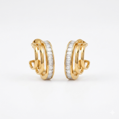 A pair of gold-plated triple-band hoop earrings for women featuring a central row of clear baguette crystals, shown on a clean white background.