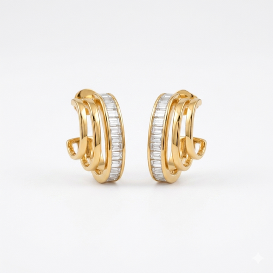 A pair of gold-plated triple-band hoop earrings for women featuring a central row of clear baguette crystals, shown on a clean white background.