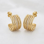 A pair of gold-plated multi-band hoop earrings for women featuring a central row of clear pavé crystals, shown on a white background.