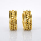 A close-view of a pair of gold-plated wide-band open hoop earrings for women featuring a detailed central braided wheat design, shown on a clean white background.