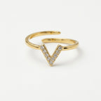 A modern gold plated adjustable ring for women featuring a "V" shaped chevron design encrusted with small shimmering crystals on a plain white background
