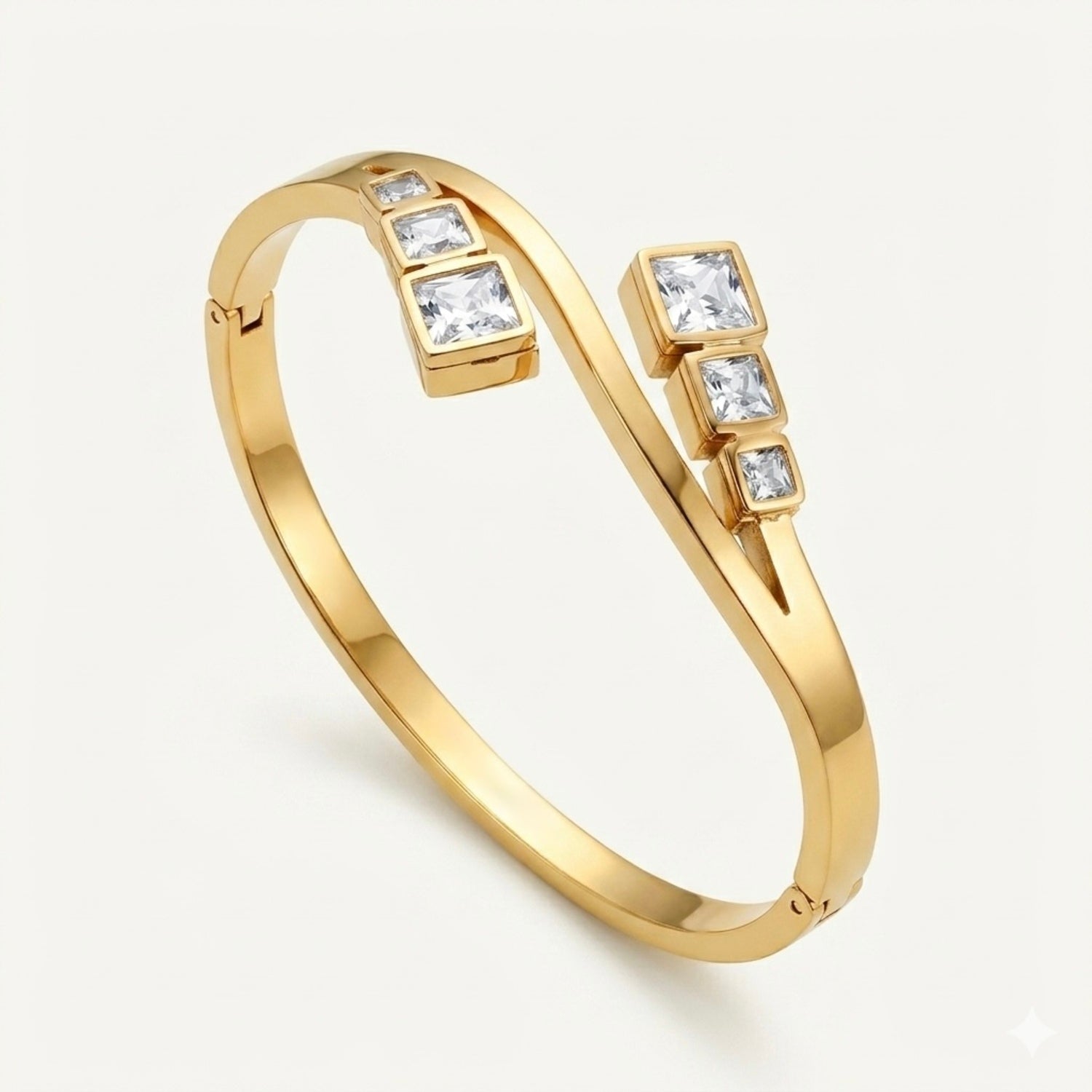 A close-view gold-plated crossover bypass bangle for women featuring graduated baguette-cut crystals and a secure side-clasp.