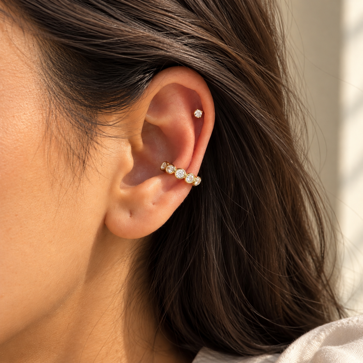 Gold-tone Crystal Ear Cuff with multiple clear faceted crystals in rounded settings, on a model