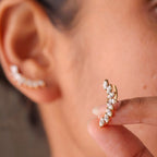 A close-view of gold-plated celestial Zenith Starburst ear climber earrings for women featuring stones and a star motif