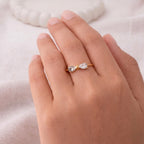 A dainty gold plated adjustable ring for women featuring a bow design on a model hand