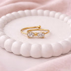 A dainty gold plated adjustable ring for women featuring a bow design shown on a white surface